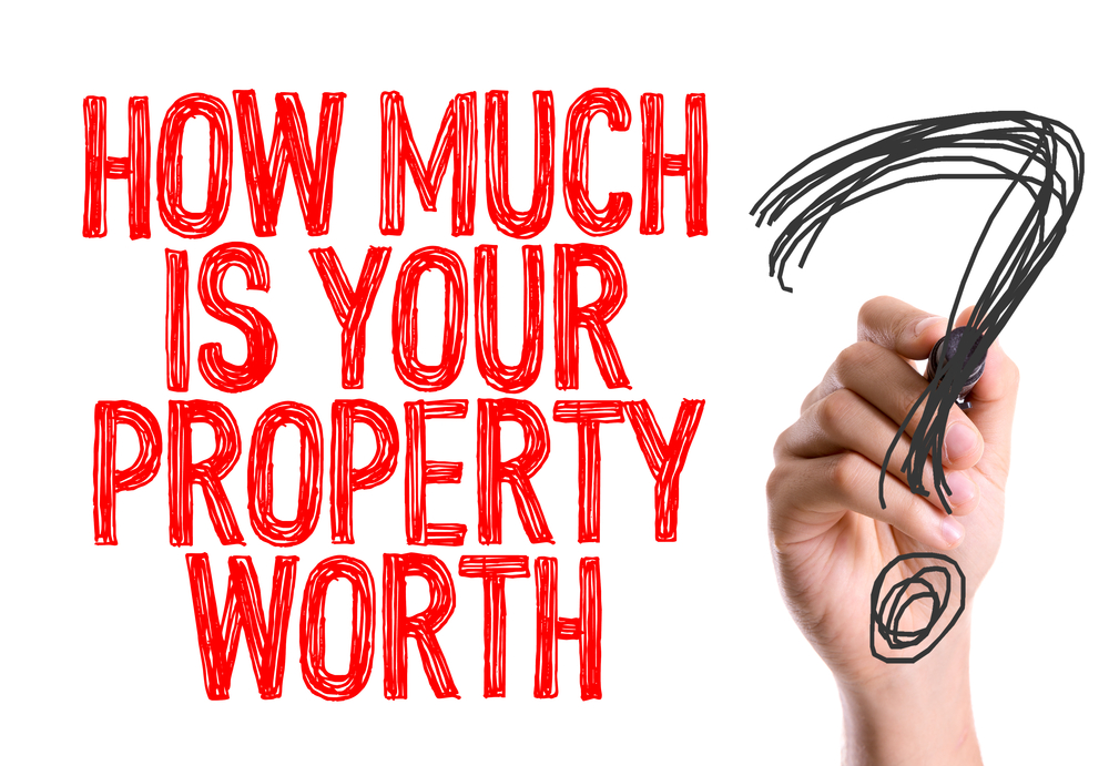 Hand with marker writing How Much Is Your Property Worth?